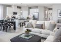 Open-concept living area with a cozy sofa, modern decor, and seamless flow to the kitchen and dining area at 1628 Covey Rise Ter, Winter Haven, FL 33884