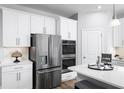 Bright kitchen featuring stainless steel refrigerator and double oven, white cabinets, and a spacious countertop at 1632 Covey Rise Ter, Winter Haven, FL 33884