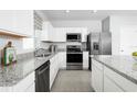 Bright kitchen with stainless steel appliances, granite countertops, and white cabinetry at 2152 Tennessee St, Sumterville, FL 33585