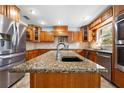 Kitchen features a large center island with stone countertops and stainless steel appliances at 10542 Cr 671, Bushnell, FL 33513