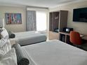 Comfortable hotel bedroom with two beds, TV, and workstation at 3000 Maingate Ln # 420, Kissimmee, FL 34747