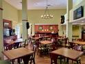 Well-lit breakfast area with tables, chairs and buffet bar at 3000 Maingate Ln # 420, Kissimmee, FL 34747