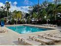 Relaxing pool area with lounge chairs and lush tropical landscaping at 3000 Maingate Ln # 420, Kissimmee, FL 34747
