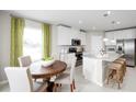 Eat-in kitchen boasts stainless appliances, granite countertops, a center island, and a cozy breakfast nook at 1180 Ivy Manor St, Minneola, FL 34715