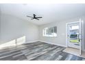 Bright living room featuring luxury vinyl plank flooring, a ceiling fan, and a well-lit entry door at 17975 Se 106Th Ct, Summerfield, FL 34491