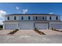 Townhome garages with brick paver driveways and professionally landscaped entries at 635 Highfalls Ave, Debary, FL 32713