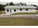 Single-story home featuring light gray siding, a metal roof, and white-framed windows at 36702 Calhoun Rd, Eustis, FL 32736