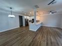 Spacious living room open to the kitchen with modern lighting, plank floors, and light walls at 36702 Calhoun Rd, Eustis, FL 32736
