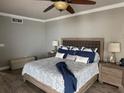 Comfortable bedroom featuring a ceiling fan, wood flooring, and a king-sized bed at 1425 Ocean Shore Blvd # 402, Ormond Beach, FL 32176