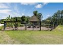 Fenced-in community garden with raised beds, mature trees, and a central gazebo seating area at 3323 Grande Heron Dr, St Cloud, FL 34773
