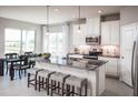 Bright kitchen with white cabinets, granite countertops, stainless steel appliances and island seating at 1916 Quail Fields Cir, Winter Haven, FL 33884