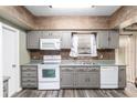 Functional kitchen featuring grey cabinets, white appliances, and a tile backsplash adding a touch of elegance at 3200 Se 34Th St, Ocala, FL 34471