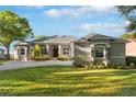 Inviting home showcasing a gray exterior, manicured landscaping, and a paved driveway leading to the garage at 248 Lake Tennessee Dr, Auburndale, FL 33823