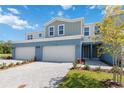 A townhome showcasing a driveway, front lawn, and inviting facade under a clear blue sky at 5244 Luisa Ct, St Cloud, FL 34771