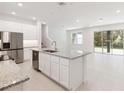Open-concept kitchen with a large island, stainless steel appliances, and sleek white cabinetry at 5244 Luisa Ct, St Cloud, FL 34771