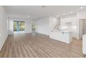 Open concept living room with luxury vinyl plank flooring and sliding glass doors to the exterior at 5248 Luisa Ct, St Cloud, FL 34771