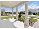 Inviting front porch showcases stylish columns, lush landscaping, and a glimpse of the neighborhood at 9432 Emerald Berry Dr, Winter Garden, FL 34787