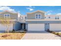 Charming townhome featuring a two-car garage, a light blue painted exterior, and manicured landscaping at 5289 Luisa Ct, St Cloud, FL 34771