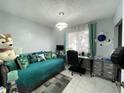 Inviting bedroom with a daybed, decorative pillows, workspace, and modern light fixture at 10867 Sw 83Rd Ct, Ocala, FL 34481