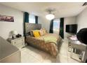 Comfortable bedroom with a tiled floor, ceiling fan, and a stylish headboard at 10867 Sw 83Rd Ct, Ocala, FL 34481