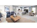 Bright living room and kitchen with white cabinets, a center island with seating, and modern design at 5004 Bear Lake Loop, Deland, FL 32724