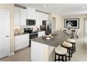 Bright, modern kitchen with granite island, white cabinets, and stainless appliances open to the dining area at 5056 Bear Lake Loop, Deland, FL 32724