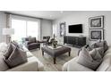 Open-concept living room with neutral tones, comfortable seating, and a view of the outdoors at 11026 Nellie Crossing Cir, Clermont, FL 34711