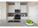 Well-appointed kitchen with granite countertops, stainless steel appliances, and white cabinetry at 5035 Bear Lake Loop, Deland, FL 32724