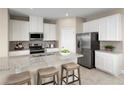Stylish kitchen with white cabinets, stainless steel appliances, granite countertops and eat-in island at 5035 Bear Lake Loop, Deland, FL 32724