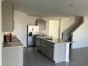 Kitchen with stainless steel appliances, granite countertops, and gray cabinets at 1707 Jindo Dr, Lake Alfred, FL 33850