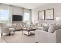 Inviting living room featuring modern decor, neutral furniture, large windows, and stylish curtains at 2088 Aibonito Cir, Clermont, FL 34711