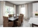 Cozy dining room area featuring modern curtains and chair setup next to a large window at 11018 Nellie Crossing Cir, Clermont, FL 34711