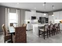 Modern eat-in kitchen featuring a large island, stainless steel appliances, and stylish pendant lighting at 11018 Nellie Crossing Cir, Clermont, FL 34711