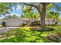 Charming single-story home with lush landscaping, a well-manicured lawn, mature trees and a large driveway at 1711 Tierra Alta Dr, Lakeland, FL 33813
