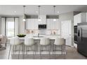 Modern kitchen featuring a center island with seating, stainless steel appliances, and pendant lighting at 3034 Cayey Way, Clermont, FL 34711