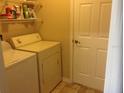 Convenient laundry room with washer, dryer, shelving, and easy access to additional storage space at 3850 Plantation Blvd, Leesburg, FL 34748