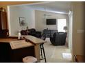 Open-concept living room featuring vaulted ceilings, ceiling fan, large windows, and tile flooring at 3850 Plantation Blvd, Leesburg, FL 34748