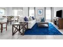 Spacious living room featuring a stylish blue rug, comfortable sofa, and dining area at 403 Harvard Ct, Dundee, FL 33838