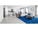 Bright living room with open-concept design, tile flooring, and modern blue accents at 403 Harvard Ct, Dundee, FL 33838