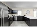 Modern kitchen featuring sleek black cabinets, stainless steel appliances, and bright white countertops at 415 Harvard Ct, Dundee, FL 33838