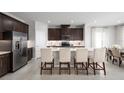 Modern kitchen with stainless steel appliances, dark wood cabinets, and white quartz countertops at 9836 Pine Mill Ct, Clermont, FL 34711