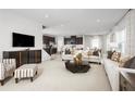 Open-concept living room with neutral walls, recessed lights, plush sofas, and views to the kitchen at 9836 Pine Mill Ct, Clermont, FL 34711