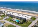 Aerial shot of a beachfront condo complex featuring a pool and scenic ocean views at 2600 Ocean Shore Blvd # 111, Ormond Beach, FL 32176