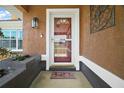 Close-up of the front door with sidelights and a decorative transom window, framed by a custom 'home' doormat at 7355 Se 106Th Pl, Belleview, FL 34420