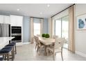 Open dining area with a stylish table and chairs set, complemented by neutral curtains and natural light at 1310 Whispering Ln, Minneola, FL 34715