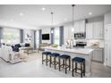 Open-concept kitchen and living area featuring a center island with seating and modern appliances at 3758 Voyageurs Ct, Apopka, FL 32712