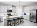 Well-lit kitchen featuring stainless steel appliances, a center island with seating, and ample cabinetry at 3758 Voyageurs Ct, Apopka, FL 32712