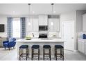 Bright kitchen with white cabinets, a center island with seating, and modern pendant lighting at 3758 Voyageurs Ct, Apopka, FL 32712