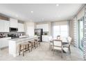 Bright kitchen features white cabinets, granite countertops, stainless steel appliances, and an adjacent dining area at 7088 Lanier Falls Rd, Deland, FL 32724