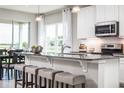 Modern kitchen with granite countertops, stainless steel appliances, a breakfast bar, and pendant lighting at 1556 Covey Rise Ter, Winter Haven, FL 33884